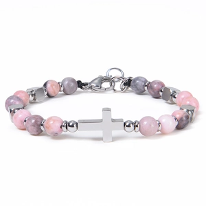 Detail of beaded bracelet with pink marble stones and a stainless steel cross charm