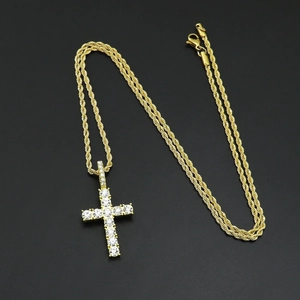 Detailed close-up of golden iced-out hip hop cross pendant with sparkling crystals