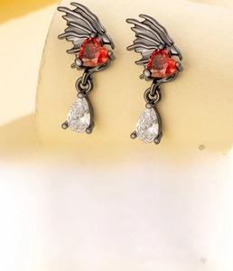 Detailed view of dragon wing ear stud with red heart zircon and screw-back in black steel