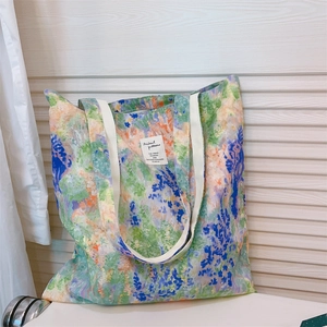 Detail of vibrant floral oil painting print and white woven strap on canvas tote bag