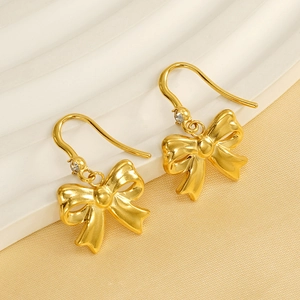 Elegant 18K gold-plated bow earrings with white rhinestones on a stylish display stand