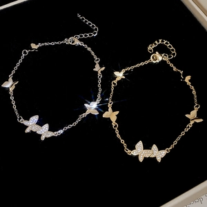 Detail view of silver and gold butterfly bracelets with sparkling cubic zirconia inlay