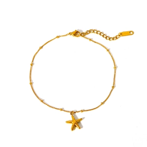 Gros plan détaillé du bracelet de cheville en acier doré avec pendentif étoile de mer et logo