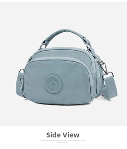 Detailed side view of light blue nylon crossbody bag featuring multi-layer zippers