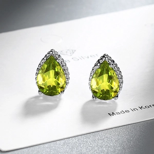 Teardrop cut lemon green zircon stud earrings in silver beaded setting on a display card