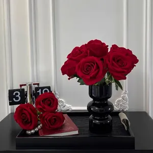 Artificial red velvet roses set in a modern black tiered vase for home tabletop decor