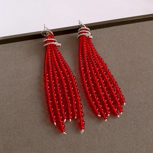 Detail of red beaded tassel earrings with sparkling diamond-encrusted silver accents