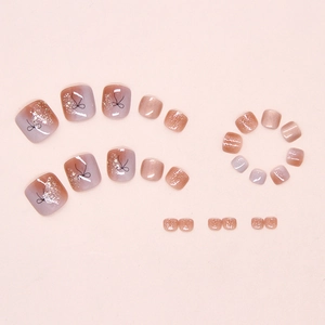 Close-up of gradient pink toe nail patches with gold glitter and black bow line art