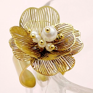Detailed macro view of golden flower napkin ring with white pearls and gold bead core