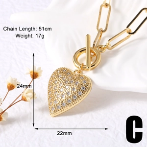 Close-up of gold heart pendant with full cubic zirconia and toggle clasp on paperclip chain