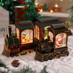Macro detail of Santa steam train snow globe with warm LED lights and glitter