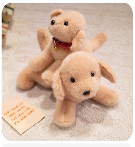 Gros plan de peluches golden retriever douces avec collier rouge sur un tapis douillet