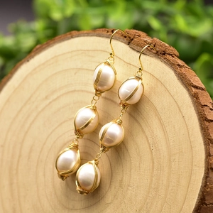 Handmade 925 silver wire wrapped natural freshwater baroque pearl earrings on wood background