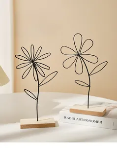 Detail of Nordic iron flower art sculpture with natural wood base on minimalist desk