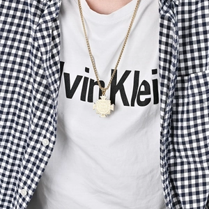 Men's gold Saint Benedict cross pendant necklace in hip-hop style worn by a male model