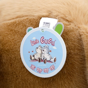 Close-up of the Little CuCu brand tag on a soft brown plush rabbit toy with fluffy texture