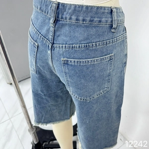 Détail du jorts en jean bleu clair avec poches arrière classiques et ourlet à bord franc