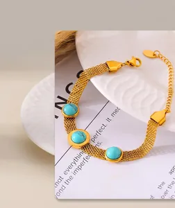 Detail of 18k gold mesh chain bracelet with turquoise charms and Roman numerals