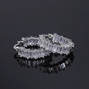 Macro detail of silver hoop earrings featuring baguette-cut AAA cubic zirconia stones