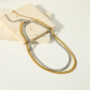 Chic 18k gold and silver flat snake chain layering necklace set on stone blocks