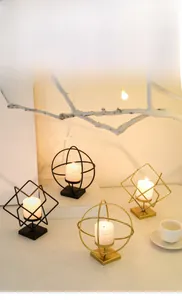 Detailed view of geometric black and gold iron candle holders for dining table decor