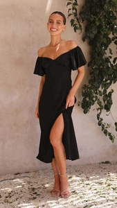 Détail d'une élégante robe en satin noir à épaules dénudées avec manches à volants et fente
