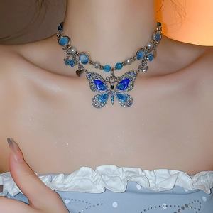 Détail de ce collier ras du cou papillon à double rangée avec émail bleu et cristaux