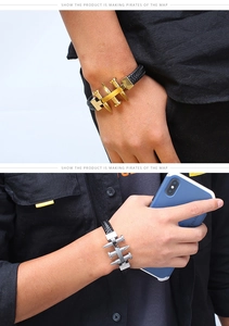 Detail of woven leather bracelet with gold and silver nail-shaped metal charms