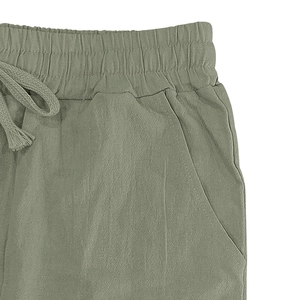Dettaglio dei pantaloni in lino verde pisello con elastico in vita e coulisse laterale