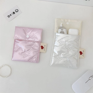 Quilted bow organizer pouch showing internal space for AirPods and electronic accessories