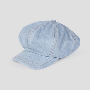 Détail de la casquette gavroche en denim bleu clair avec coutures rétro et bouton