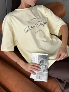 Detail showing soft cotton texture and Saint Tropez print on a loose cream t-shirt