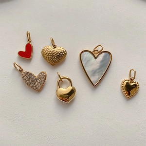 Detailed close-up of six gold heart pendants with pearl, enamel, and crystal textures