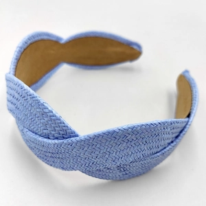 Macro detail of hand-woven light blue raffia braided headband with comfortable inner lining