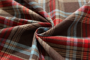 Macro detail of red and green plaid table cloth fabric showing soft woven texture