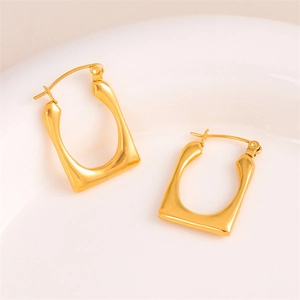 Modern gold-plated stainless steel U-shaped geometric earrings on a minimalist white plate