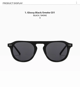 Close-up of black round sunglasses frame with silver rivet details and smoke lenses