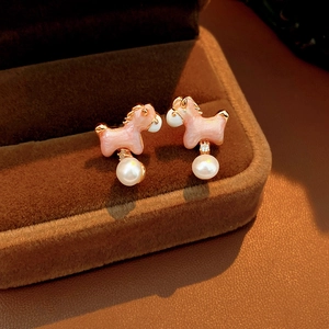 Detailed view of pink pony stud earrings with white pearl pendants on jewelry box