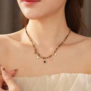 Close-up of ethnic sun and star pendants on a beaded necklace with tiger eye accents