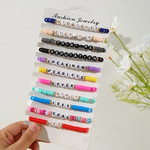 Close-up of Taylor Swift friendship bracelets with album names and colorful beads