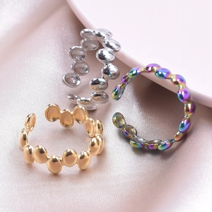 Detail of adjustable bubble-shaped stainless steel rings in gold, silver, and rainbow finish
