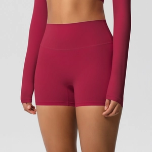Macro shot of seamless high-waist wine red yoga shorts and long sleeve crop top