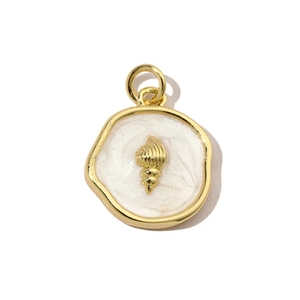 Macro detail of a golden shell pendant with white enamel and polished metal finish