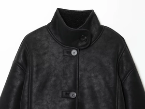 Close-up of black faux suede jacket featuring soft shearling lining and button details