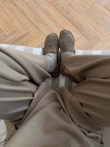 Gros plan de mocassins en daim marron avec chaussettes grises et pantalon en maille kaki
