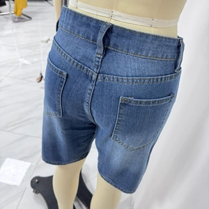 Close-up of the back pockets and washed denim texture of these blue cropped jeans