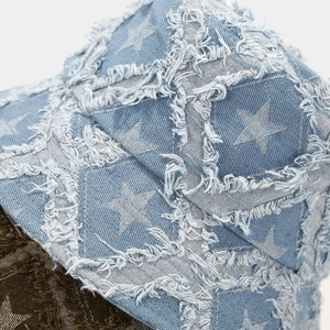Gros plan de la broderie étoile effilochée sur le chapeau bob en denim bleu clair
