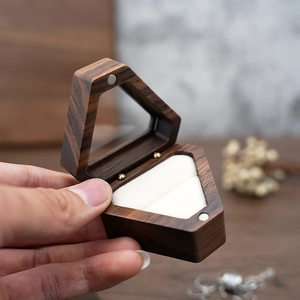 Macro view of hexagonal walnut wood jewelry box with magnetic closure and beige velvet lining