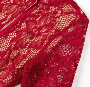 Détail du tissu en dentelle florale rouge avec fermeture éclair assortie sur la robe