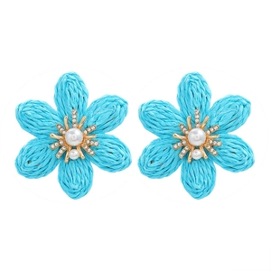 Detailed view of sky blue woven raffia flower earrings with pearls and crystals